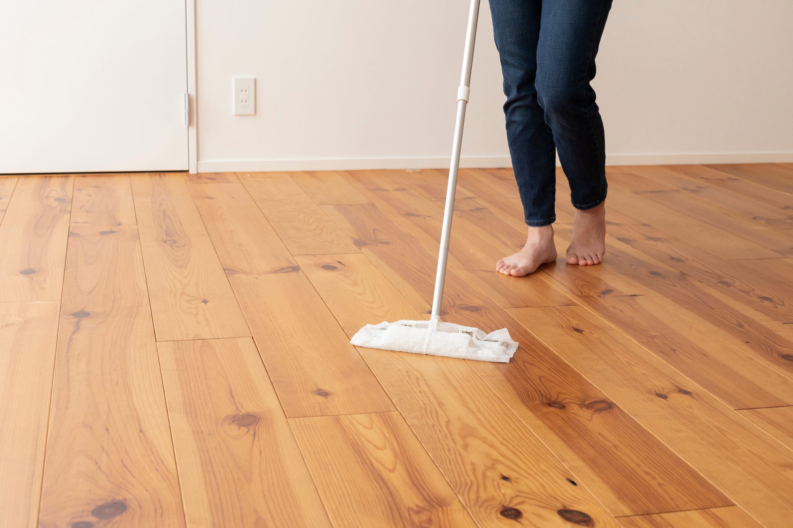 Wood Floor Sanding in south-west-london — aftercare cleaning of engineered oak hardwood plank flooring with a flat mop on a newly restored surface.