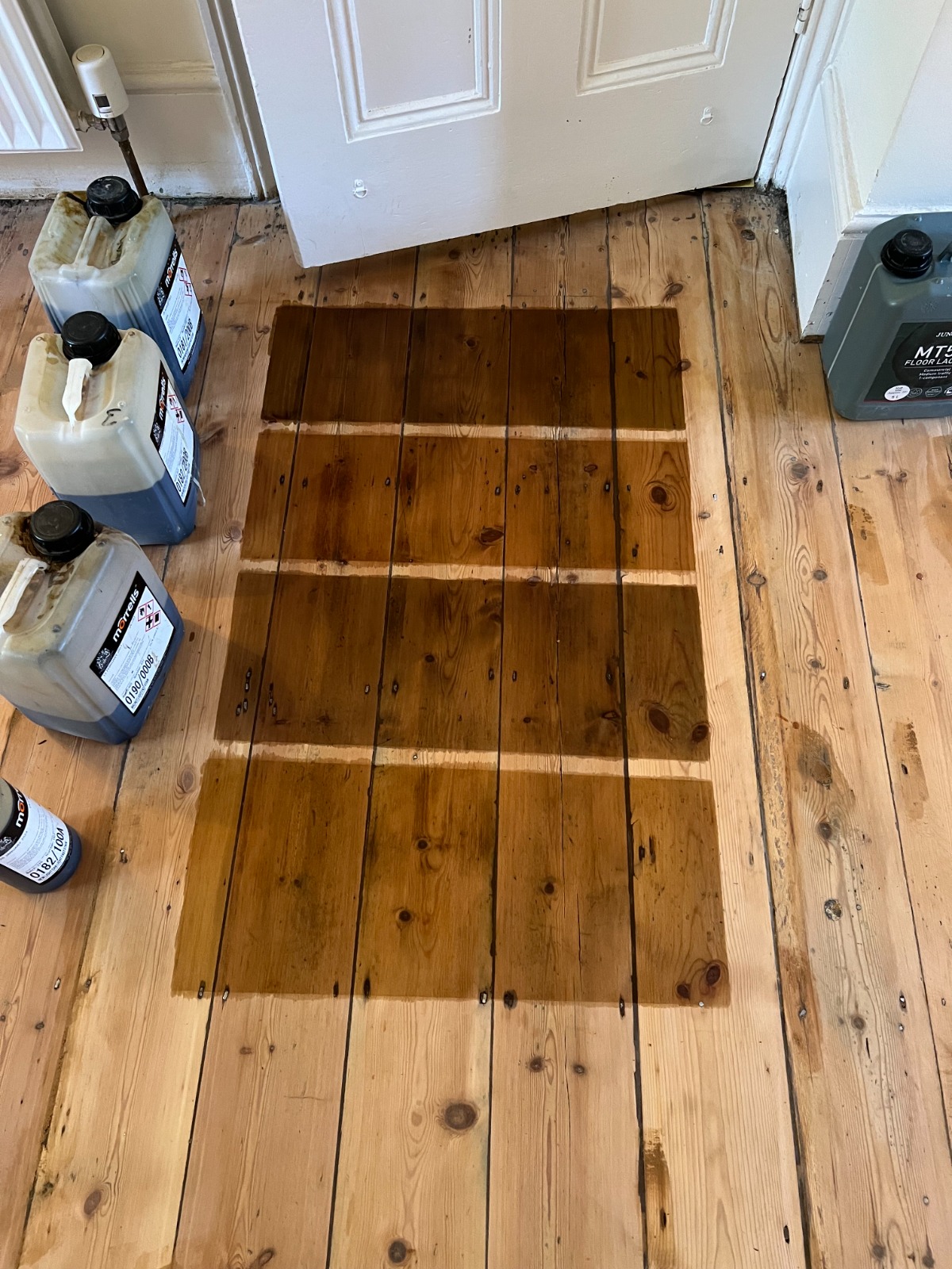 Wood Floor Sanding in south-west-london — stain sample grid tested on Victorian softwood pine floorboards after sanding, to choose the final colour and finish.