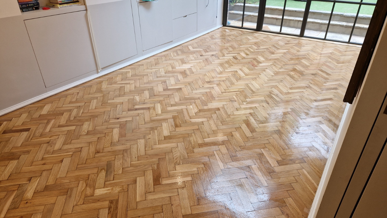Parquet Floor Sanding in south-west-london living room on a light oak herringbone parquet wood floor, fully restored with a smooth, glossy finish.